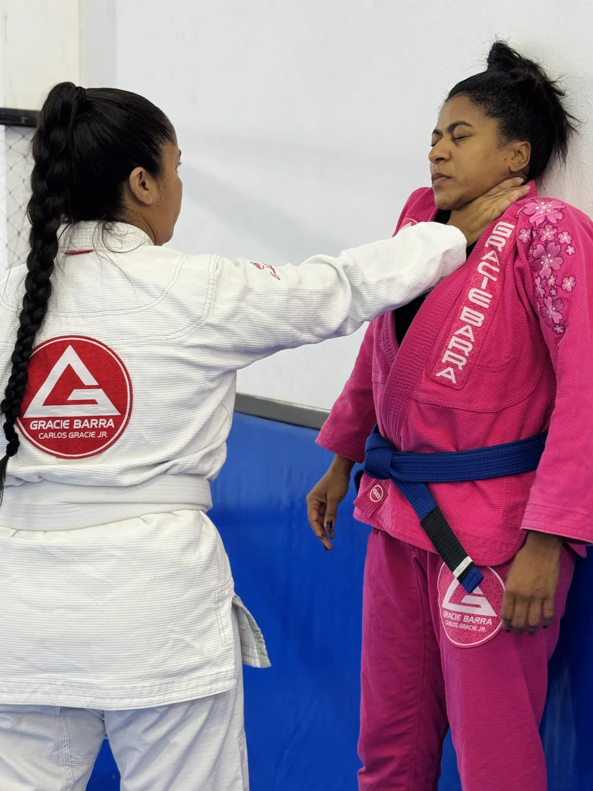 Alunas praticando defesa pessoal contra a parede durante o curso